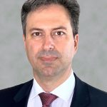 Nikos Michailidis Man on a grey background in a suit looking straight