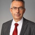 Man in glasses on a grey background smiling to camera